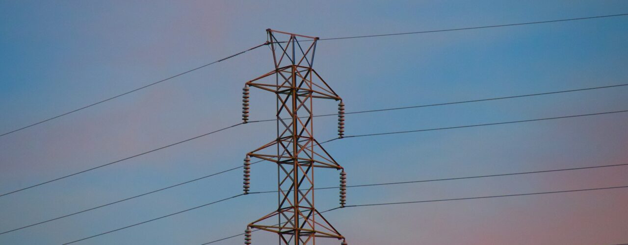 a high voltage power line against a blue sky