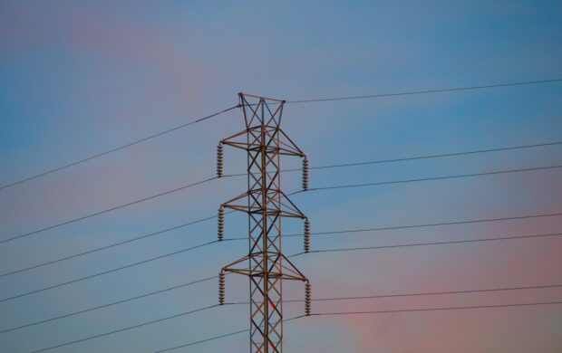 a high voltage power line against a blue sky